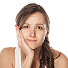 Woman holding her cheek in pain