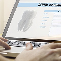 person filling out a dental insurance form on a laptop