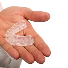 Holding an athletic mouthguard to prevent dental emergencies in Edison, NJ