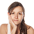 Woman holding cheek in pain