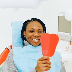 Woman in dental chair looking in mirror