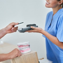 A man using a credit card to pay the cost of dental crowns