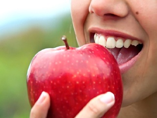 person biting into red apple