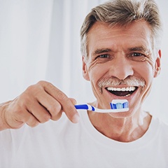 man brushing his teeth 