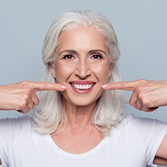 woman pointing to her smile