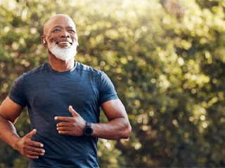 Bearded man in blue shirt jogging outside