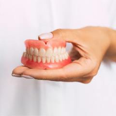 Close-up of a person holding dentures in Edison, NJ