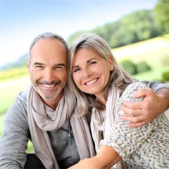 Senior man and woman sitting together outside