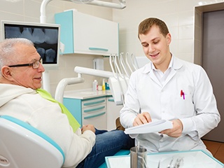 Emergency dentist in Edison helping an older patient