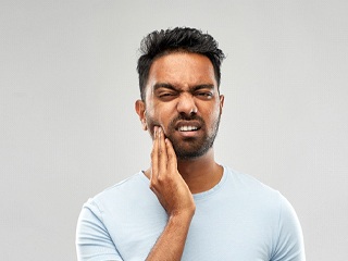 person holding their mouth because they have a toothache in Edison