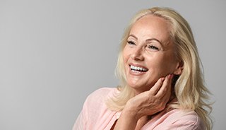 Older woman with implant dentures in Edison smiling