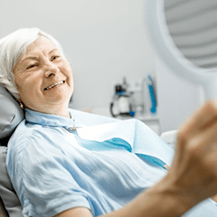 a patient smiling after receiving dental implants in Edison