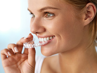 Woman placing Invisalign tray