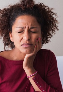 Woman with toothache sitting on couch at home