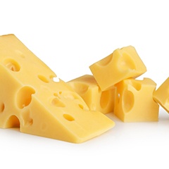 Several blocks of cheese sitting on white cabinet