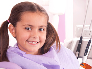 Smiling young girl in dental chair