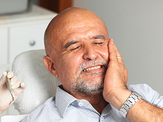 Man holding cheek in pain