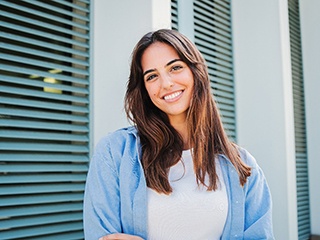 Woman with white teeth smiling while standing outside