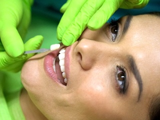 dentist placing a veneer over a patient’s tooth