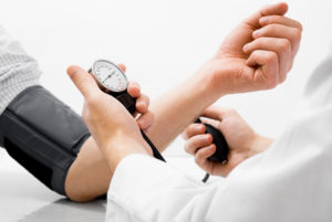 woman taking man’s blood pressure