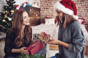 two women smiling exchanging gifts