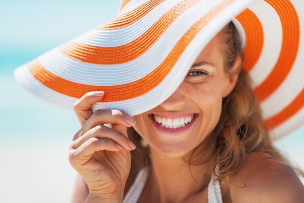 Woman smiling on the beach during summertime.