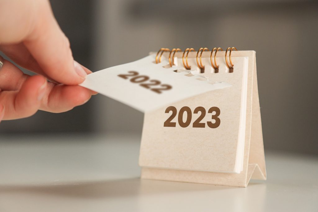 Person tearing off 2022 to reveal 2023 calendar