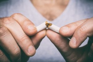 a man breaking a cigarette in half