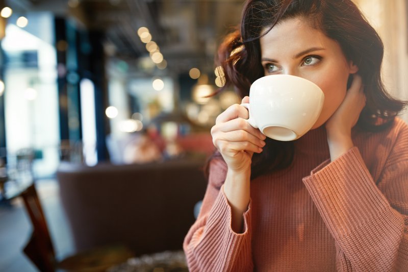 person smiling and drinking coffee