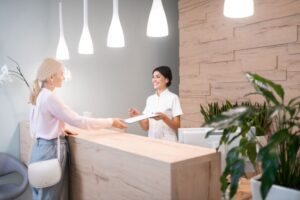 Dental team member assisting patient at front desk 