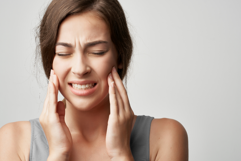 Woman holding jaw in pain