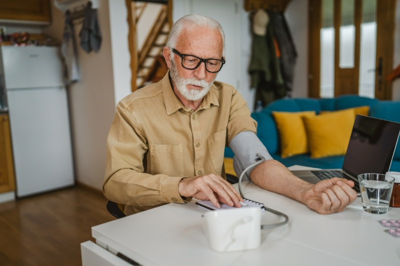 Man with gum disease checking blood pressure