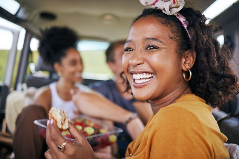 Veneers patient smiling while eating with friends